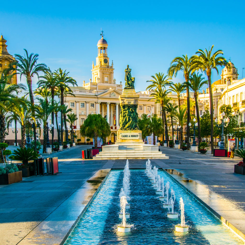 View of a fountain situated on the square of saint john of god in cadiz with town hall on background