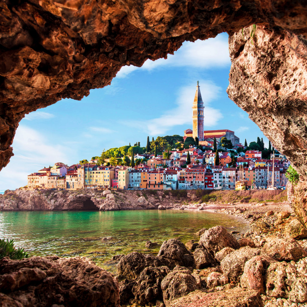 Unusual view with old clock towe in Piran through a rock hole. the tourist center of Slovenia. popular tourist attraction. Wonderful exciting places.