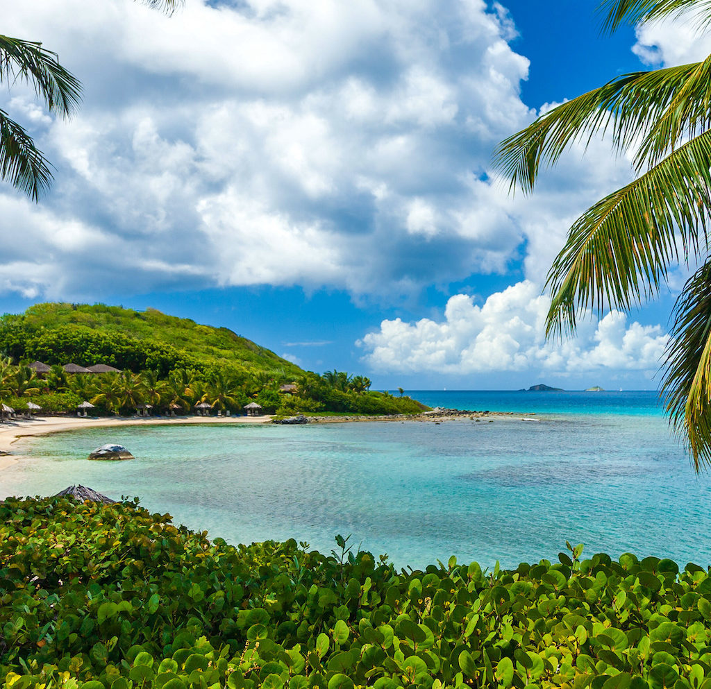 Huts along a tranquil tropical beach on  Virgin Gorda, British Virgin Islands.